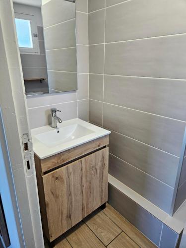 a bathroom with a sink and a mirror at Hôtel La Frégate in Fécamp