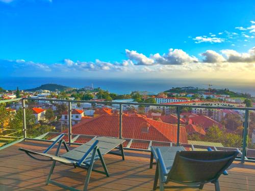 a patio with two chairs and a table on a balcony at Skyline Home Funchal in Funchal