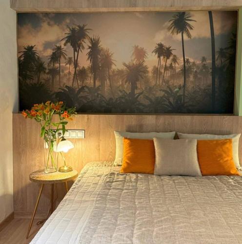 a bedroom with a bed with a painting of palm trees at Mayachok Boutique hotel in Kyiv