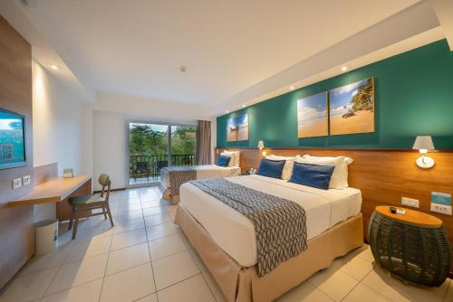 a hotel room with a large bed and a desk at Salinas Maceio All Inclusive Resort in Maceió