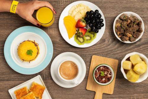 a table with plates of food and bowls of fruit at Salinas Maceio All Inclusive Resort in Maceió