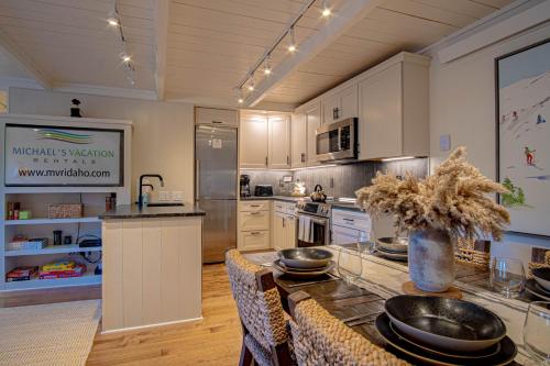 a kitchen with a table with plates on it at Atelier Alpine - Modern 2BD Condo w/Baldy Views in Sun Valley