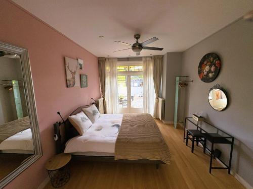 a bedroom with a large bed and a mirror at Sfeervol appartement met tuin bij centrum & station in Dordrecht