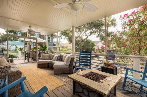 a patio with blue chairs and a table at Sandy Paws Retreat - 30 Day Rental in Folly Beach