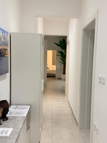 a hallway with white walls and a hallway with a mirror at The White Balcony in Il-Gżira
