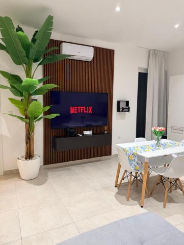a living room with a tv and a table and chairs at The White Balcony in Il-Gżira