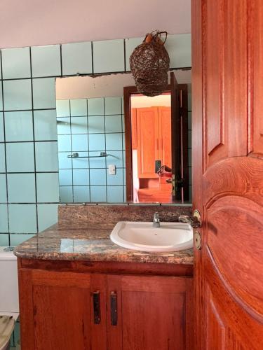 a bathroom with a sink and a mirror at BEACH HOUSE pé na areia in Santa Cruz Cabrália
