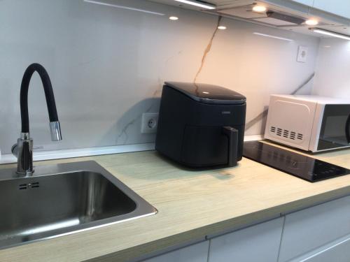 a kitchen with a toaster and a microwave on a counter at Puerto playa B in Malpica