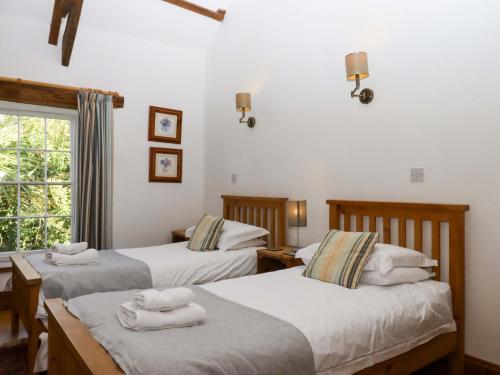 a bedroom with two beds and a window at Oak Tree in Halwell