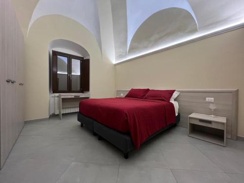 a bedroom with a bed with red sheets and a window at Il Poggetto Bed and Breakfast in Bovino