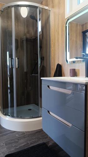 a bathroom with a glass shower and a sink at Domki Ale Góry Beskid Żywiecki Korbielów in Korbielów