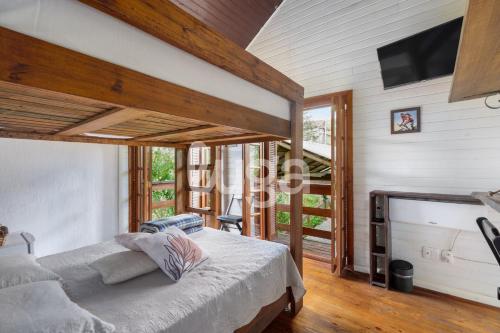a bedroom with a bed and a flat screen tv at Suíte Front Cyclists' Paradise in Gramado
