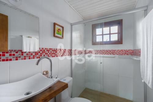 a white bathroom with a shower and a toilet at Suíte Front Cyclists' Paradise in Gramado