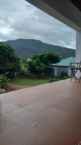 a porch with a bench and a view of a mountain at Jacaranda Home in Mbeya