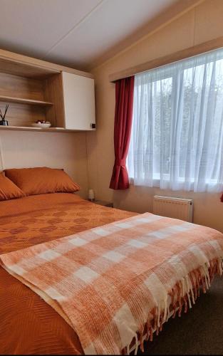 a bedroom with a bed and a window at Orange Caprice Escape, Church Farm in Pagham