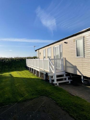 a mobile home with a porch and a deck at Harbour Escape - Church Farm in Pagham