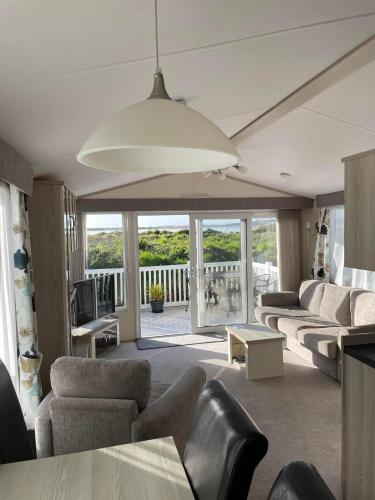 a living room with couches and a balcony at Harbour Escape - Church Farm in Pagham