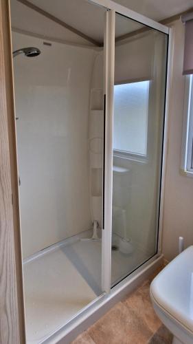 a glass shower in a bathroom with a toilet at Harbour Escape - Church Farm in Pagham