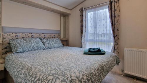 a bedroom with a bed and a window at Harbour Escape - Church Farm in Pagham