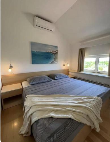 a bedroom with a large bed and two windows at HH Antona with Private Pool in Puljane