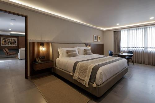 a bedroom with a large bed and a desk at Origen 438 Luxury Boutique Hotel in Guadalajara