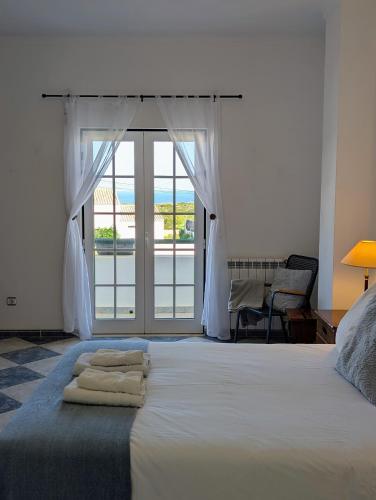 a bedroom with a bed with a view of the ocean at Casa Machado in Sagres
