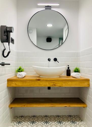 a bathroom with a sink and a mirror at La Aduana - The Lodging Experience in Astorga