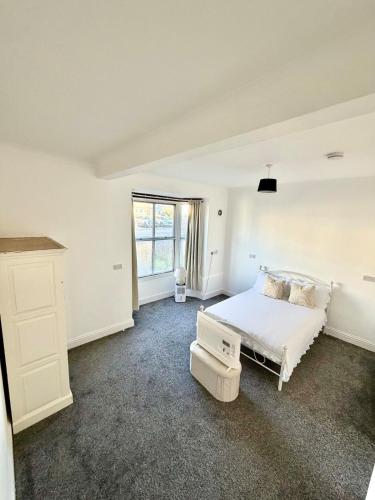 a white bedroom with a bed and a window at Private Apartment Free parking Gatwick Airport - One bedroom- One sofa Bed in Horley