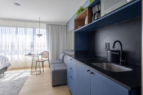 a kitchen with a sink and a table in a room at Edificio ON in Blumenau