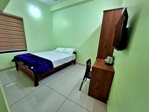 a bedroom with a bed and a tv in it at Sivasakthi Inn in Trivandrum