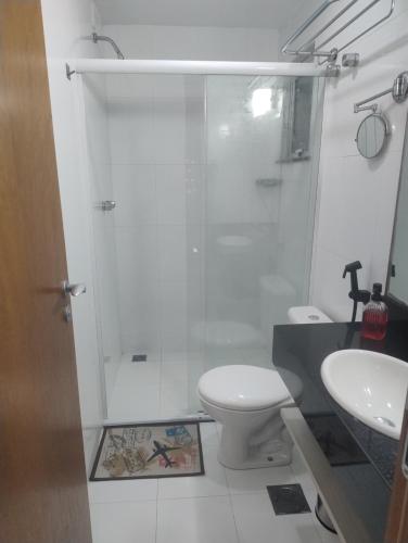 a bathroom with a shower and a toilet and a sink at Inefável flat Porto Marina Resort in Mangaratiba