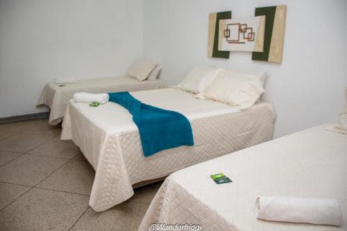 a room with three beds with a blue blanket on them at Hotel Estação Trem Guararema in Guararema