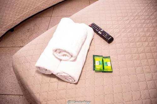 a pair of towels and a remote control on a bed at Hotel Estação Trem Guararema in Guararema