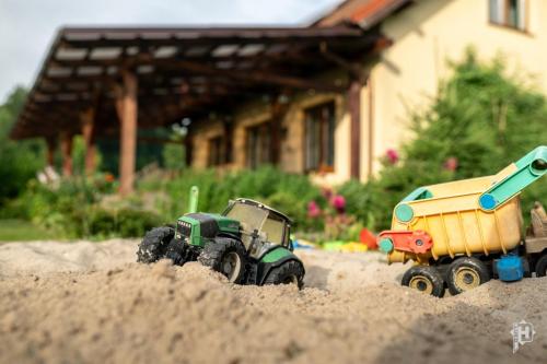 two toy trucks in the sand in front of a house at Majcia in Jelenia Góra