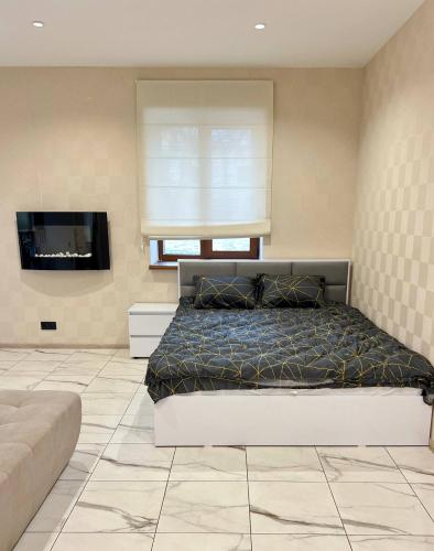 a bedroom with a bed and a flat screen tv at Троїцька площа 3 Квартира Самий Центр Окремий Вхід in Dnipro