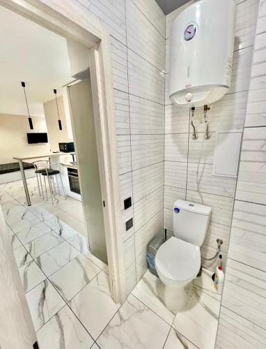 a white bathroom with a toilet and a kitchen at Троїцька площа 3 Квартира Самий Центр Окремий Вхід in Dnipro