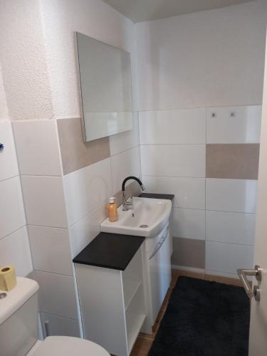 a white bathroom with a sink and a toilet at Privatunterkunft Kaning in Kaning
