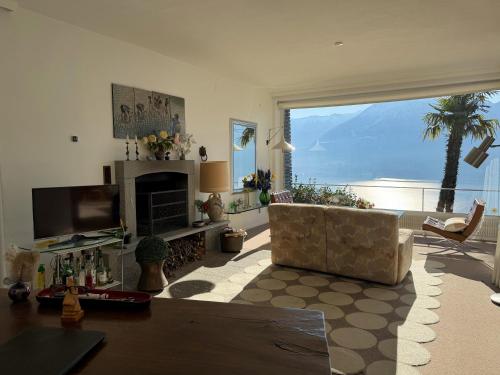 a living room with a couch and a large window at Casa Rocca Nera by HolAp in Ronco sopra Ascona