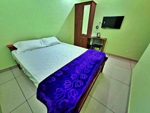 a bedroom with a bed with a purple blanket at Sivasakthi Inn in Trivandrum