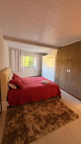 a bedroom with a red bed with a red blanket at Refúgio no Interior in Domingos Martins