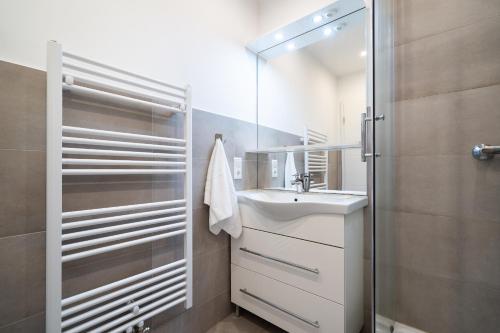 a white bathroom with a sink and a shower at Panoramic App B07-1 in Sierksdorf