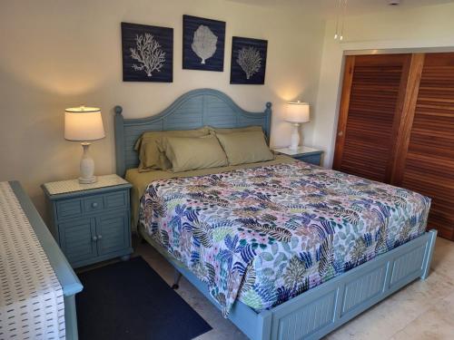 a bedroom with a blue bed and two night stands at The Flip Flop Villa in Christiansted