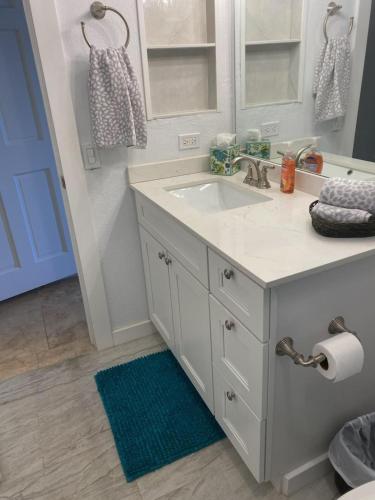 a bathroom with a sink and a blue rug at The Flip Flop Villa in Christiansted