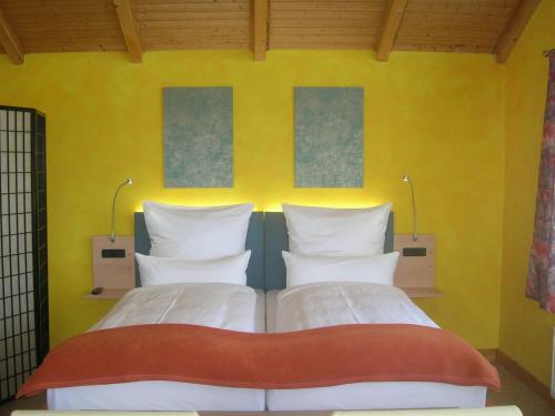 a bedroom with two beds and a yellow wall at Casa Andelka in Andělská Hora