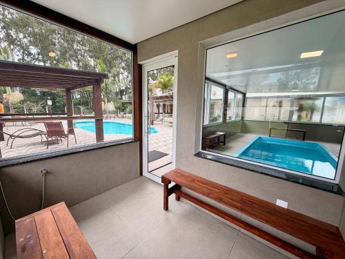 a house with a swimming pool and a bench at Pousada Recanto das Cerejeiras in Rio Grande