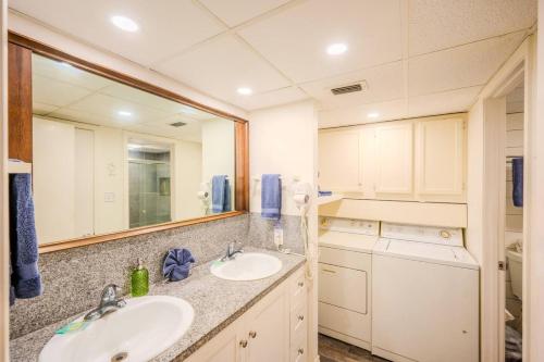a bathroom with two sinks and a large mirror at Five O Clock Somewhere in Port Aransas