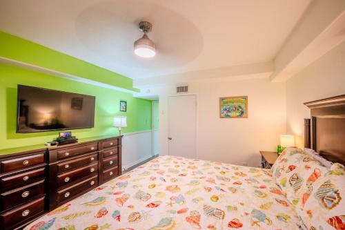 a bedroom with a bed and a flat screen tv at Five O Clock Somewhere in Port Aransas