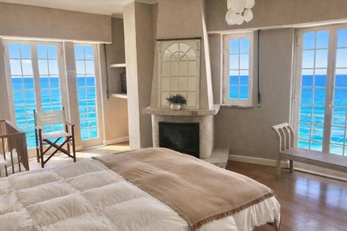 a bedroom with a large bed and a fireplace at Atlantic Views Sintra Guest House in Colares