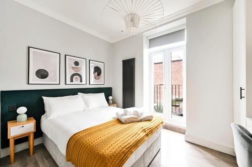 a bedroom with a bed and a window at The Collection Stays Chelsea in London