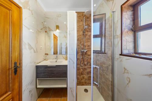 a bathroom with a sink and a shower at "Orange Tree Villa in Alvor - South - facing Family Villa with Private Poll" in Alvor